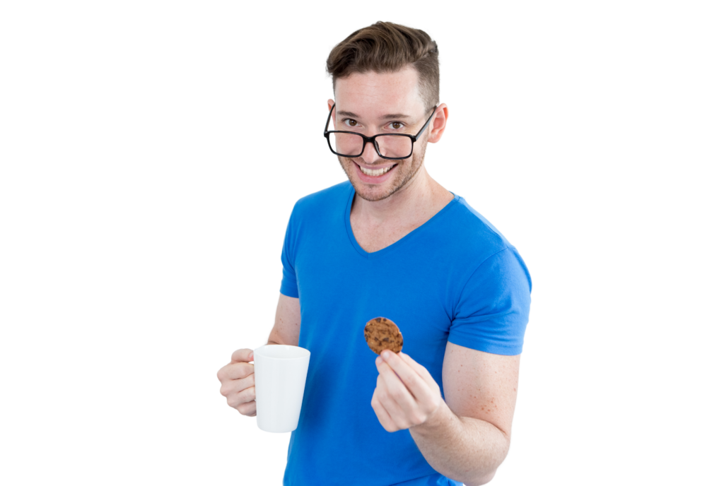 Man in a blue shirt smiles while holding a cookie in one hand and a white mug in the other informative and concise